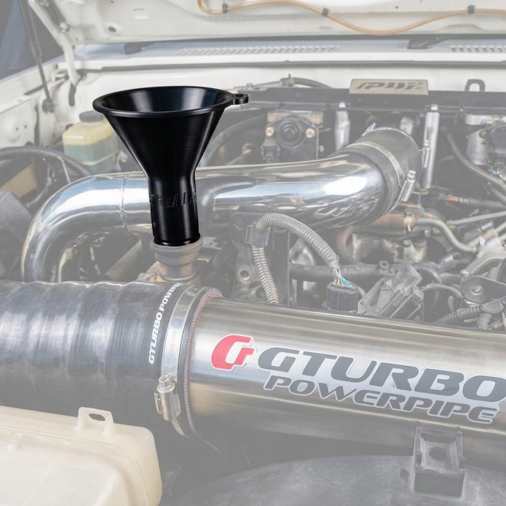 A GT Turbo Powerpipe stainless steel intake pipe installed in a vehicle engine bay, with a Cruiser Worx black funnel inserted into the upper valve cover oil fill hole. 