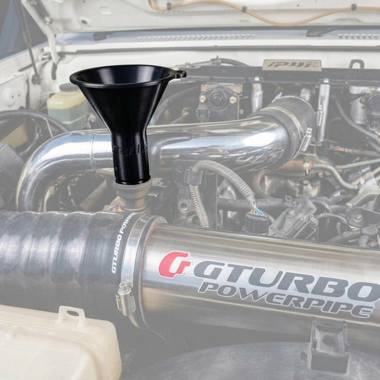 A GT Turbo Powerpipe stainless steel intake pipe installed in a vehicle engine bay, with a Cruiser Worx black funnel inserted into the upper valve cover oil fill hole. 